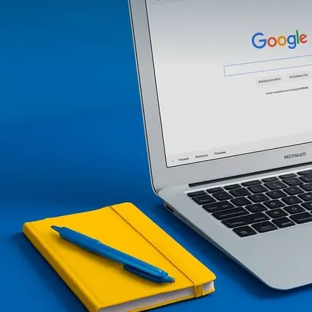 A yellow notebook and pen on a blue desk